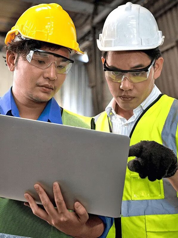 Two workers looking at laptop.